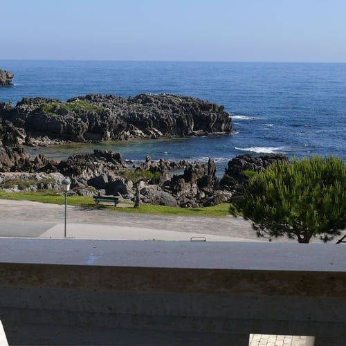 Sea views from Torre Cristina: rocks, beach, and blue ocean.