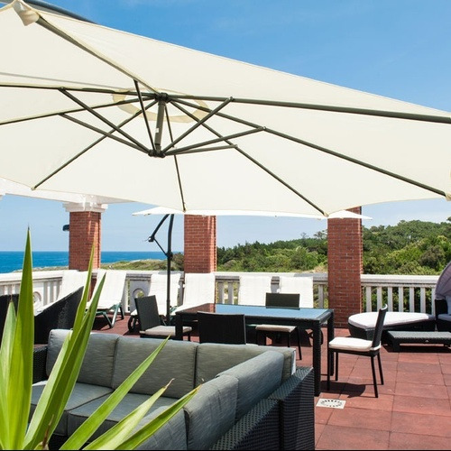 Torre Cristina terrace with sea views, outdoor furniture, and umbrella.