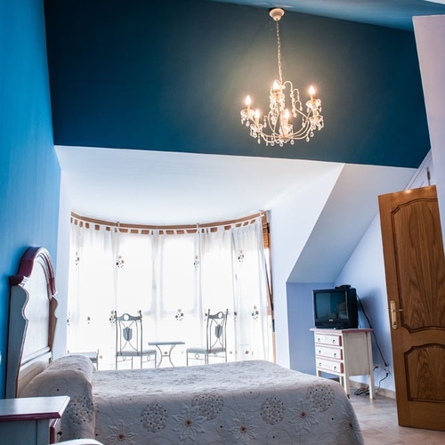 Elegant hotel room with comfy bed and crystal chandelier at Torre Cristina.