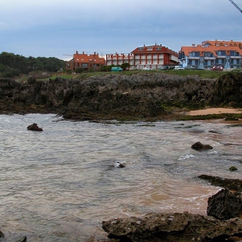 Torre Cristina Hotel: ocean views and rocky coast, featuring Mediterranean-style buildings.