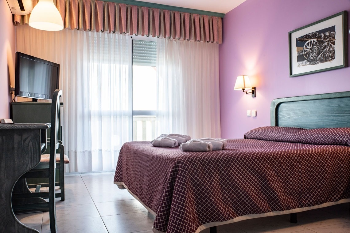 una habitación morada con una cama y una televisión