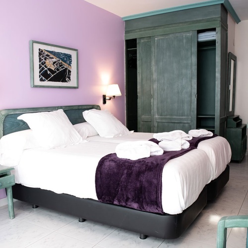 Modern room at Torre Cristina with comfortable bed and green wardrobe.