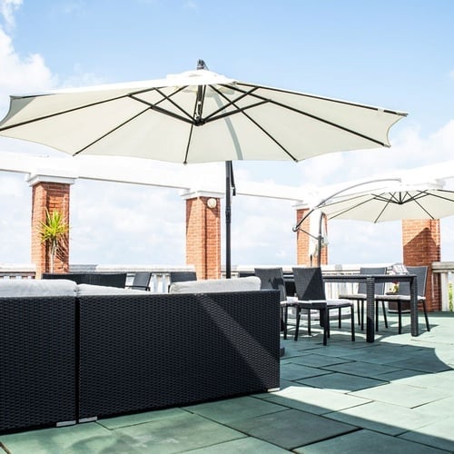 Torre Cristina terrace: sofas, tables under umbrellas, sea views.