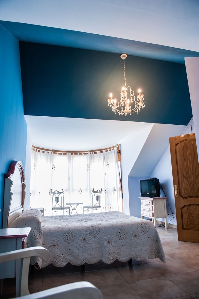 a bedroom with a chandelier hanging from the ceiling
