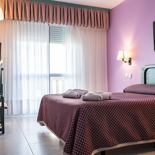 Modern room at Torre Cristina featuring a double bed, TV, and balcony.