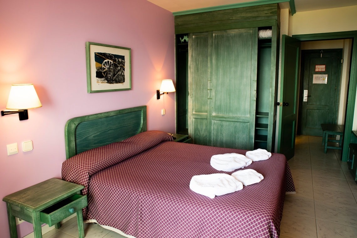 una habitación de hotel con una cama y un armario verde