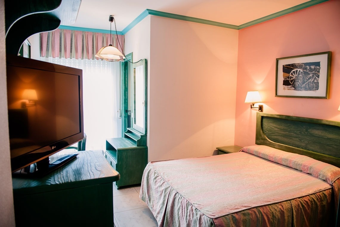 una habitación con una cama y una televisión lg