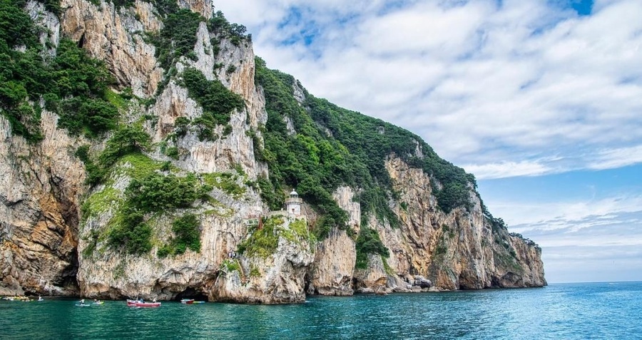 un faro en la cima de una roca en medio del océano