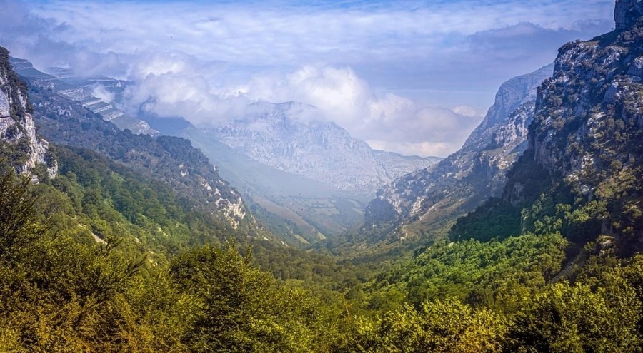 una vista aérea de una playa con un pequeño pueblo en la distancia .