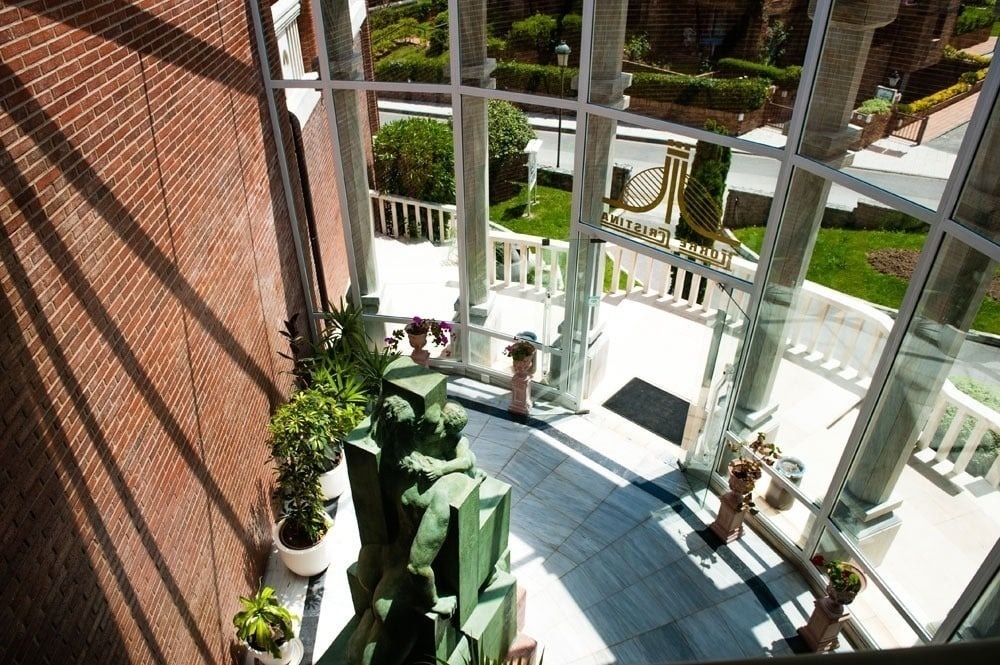 una piscina en forma de piano está rodeada de sillas y autos