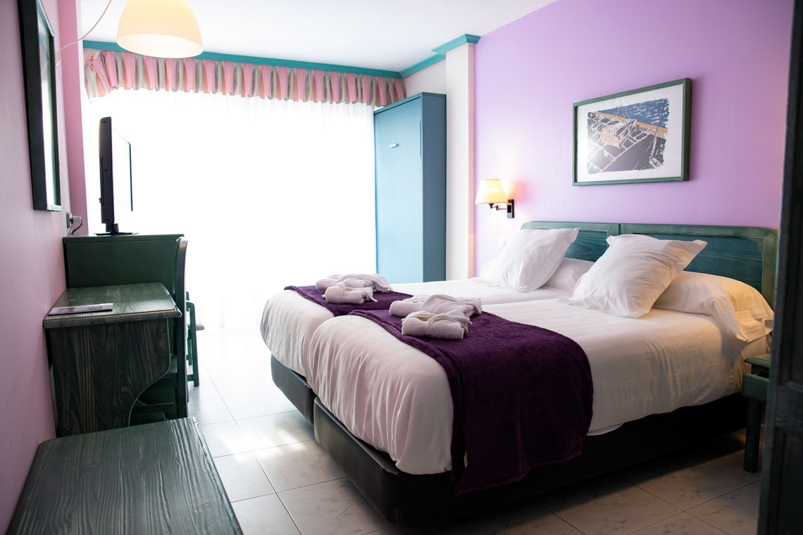 una habitación con dos camas y una pintura en la pared