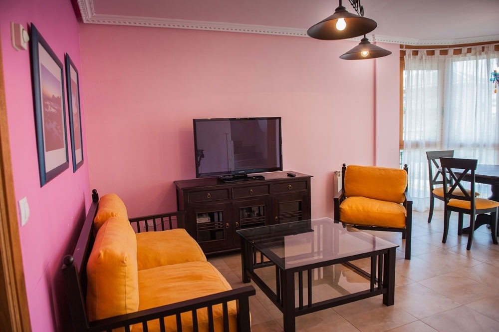 a living room with a yellow couch and a flat screen tv