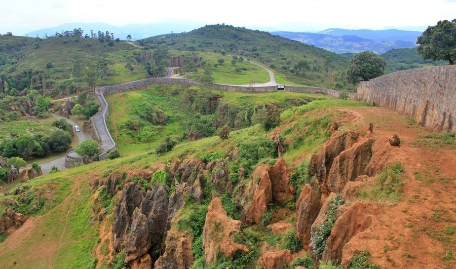 un camino serpentea a través de un valle rodeado de montañas