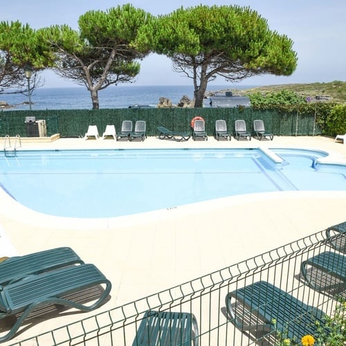 Torre Cristina hotel pool with sun loungers and sea views.