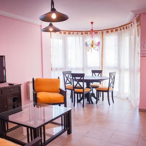 Cozy dining area at Torre Cristina with round table and chairs, by window and door.