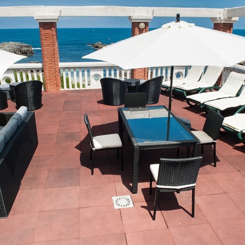 Torre Cristina terrace with sea views: sofas, chairs, and lounge chairs.