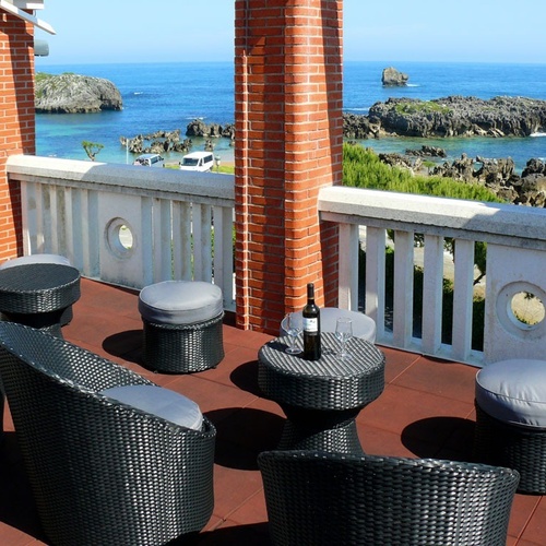Torre Cristina terrace overlooking the sea, with outdoor furniture and wine glasses.