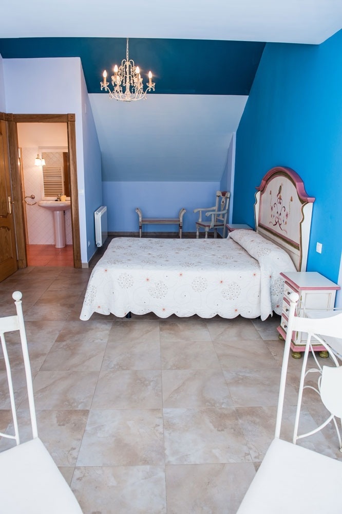 a bedroom with blue walls and a white bed