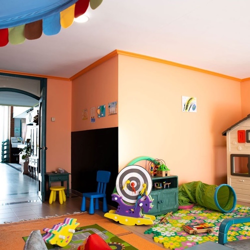 Colorful children's play area at Torre Cristina with toys, tunnel, and playhouse.