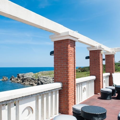 Sea view terrace at Torre Cristina, outdoor furniture, and blue sky.