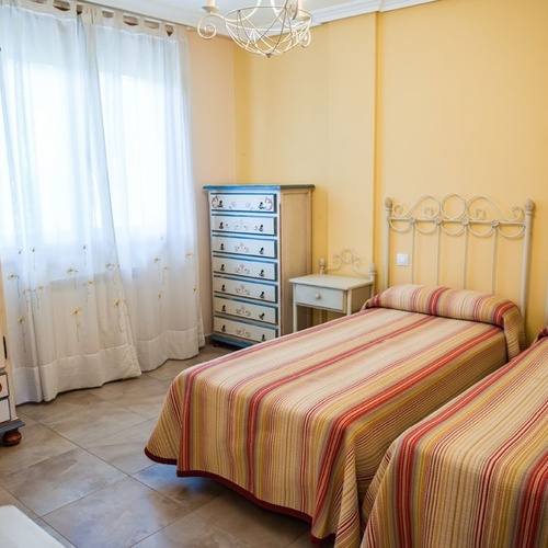 Twin bedroom at Torre Cristina, featuring hand-painted furniture and a bright, cheerful ambiance.