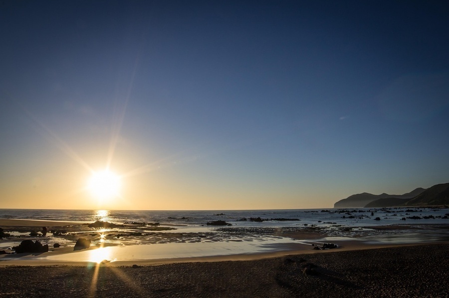 una vista aérea de una playa con un pequeño pueblo en la distancia .