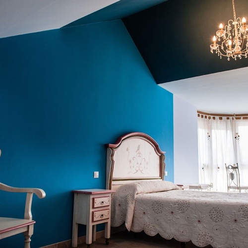 Luxury room at Torre Cristina with bed, chair, and fireplace.