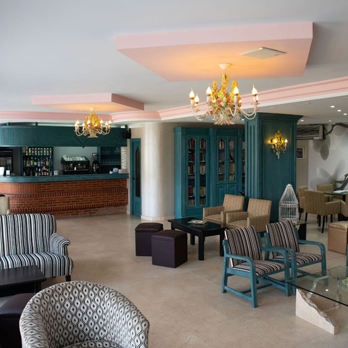 Cozy lounge at Hotel Torre Cristina with sofas, armchairs, and bar area.