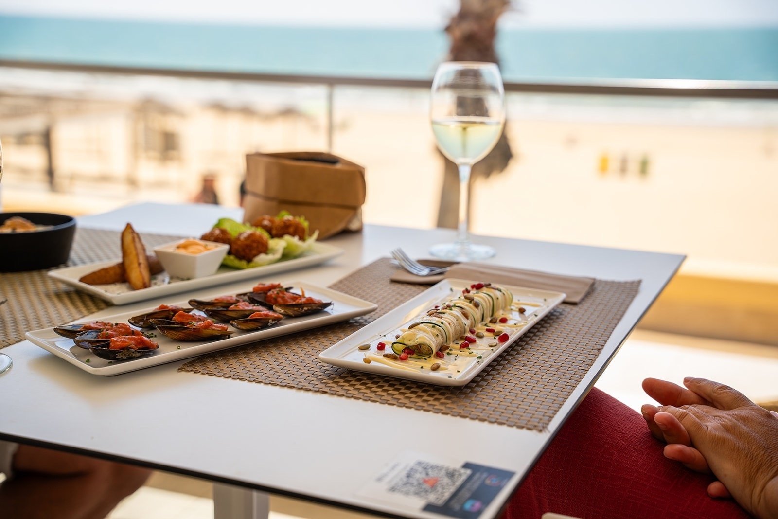 una mesa con platos de comida y una copa de vino