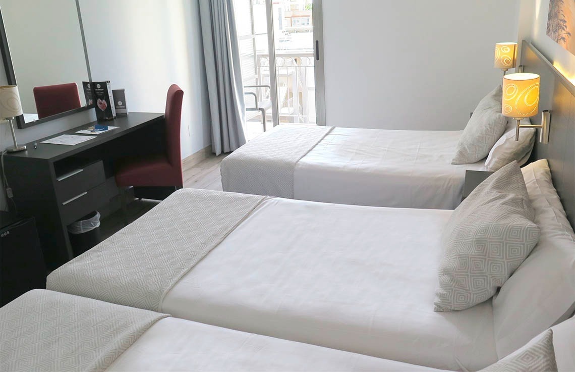a hotel room with two beds and a desk