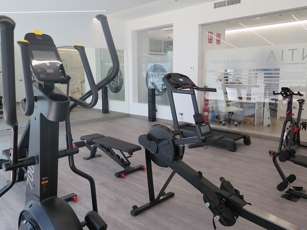 un gimnasio con equipos de ejercicio y la palabra alta en la pared