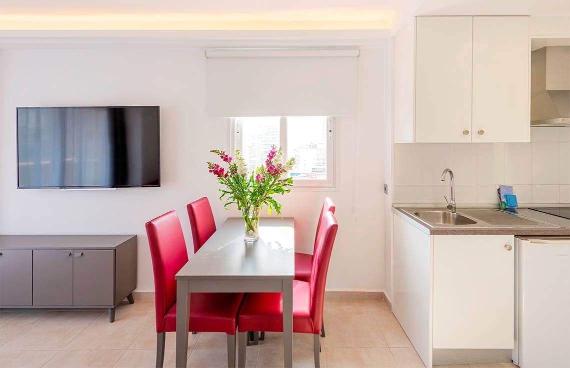 a kitchen with a table and chairs and a flat screen tv