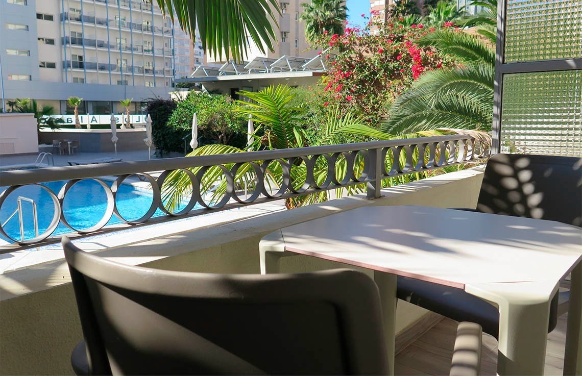 a balcony overlooking a swimming pool with a sign that says ' ibiza ' on it