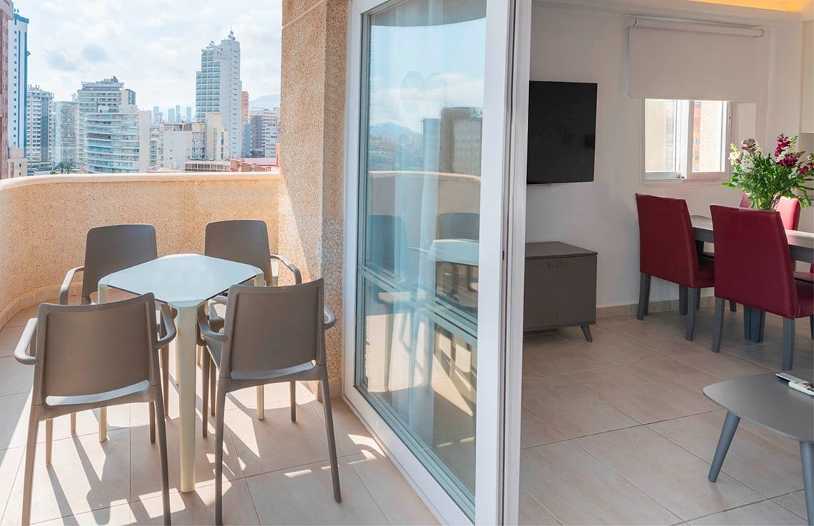 a table and chairs on a balcony with a view of a city