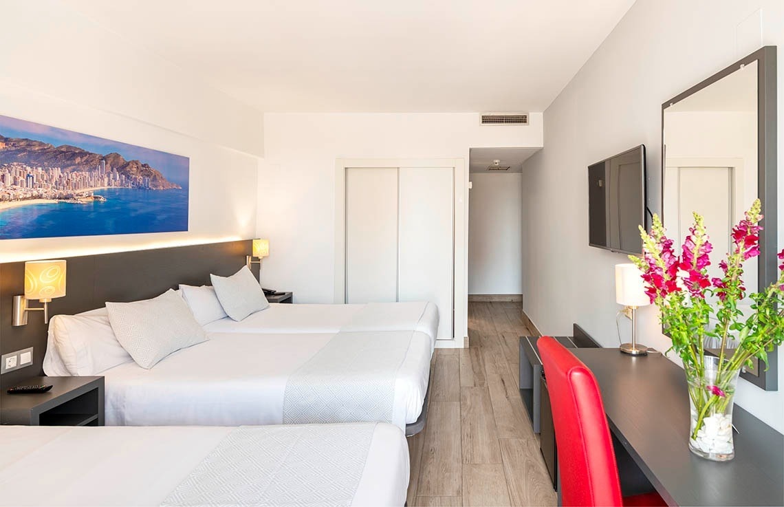 a hotel room with two beds and a painting on the wall