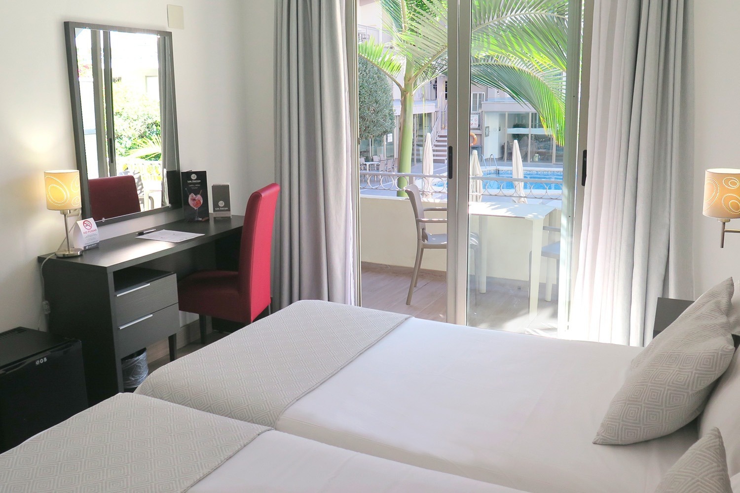 a hotel room with two beds and a sliding glass door