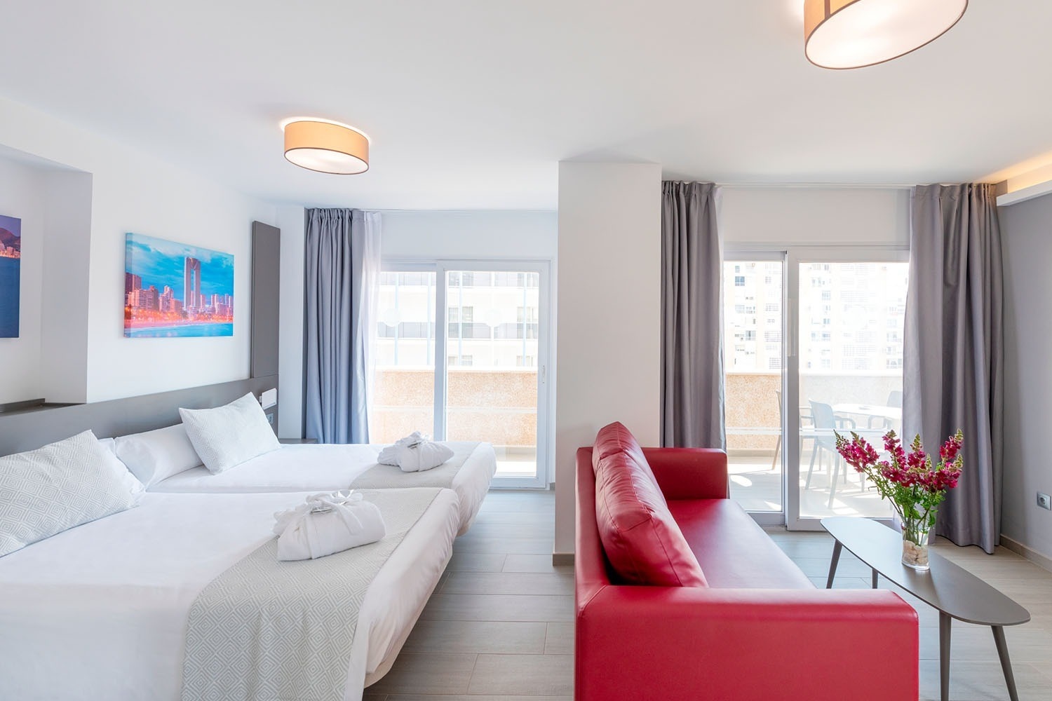 a hotel room with two beds and a red couch
