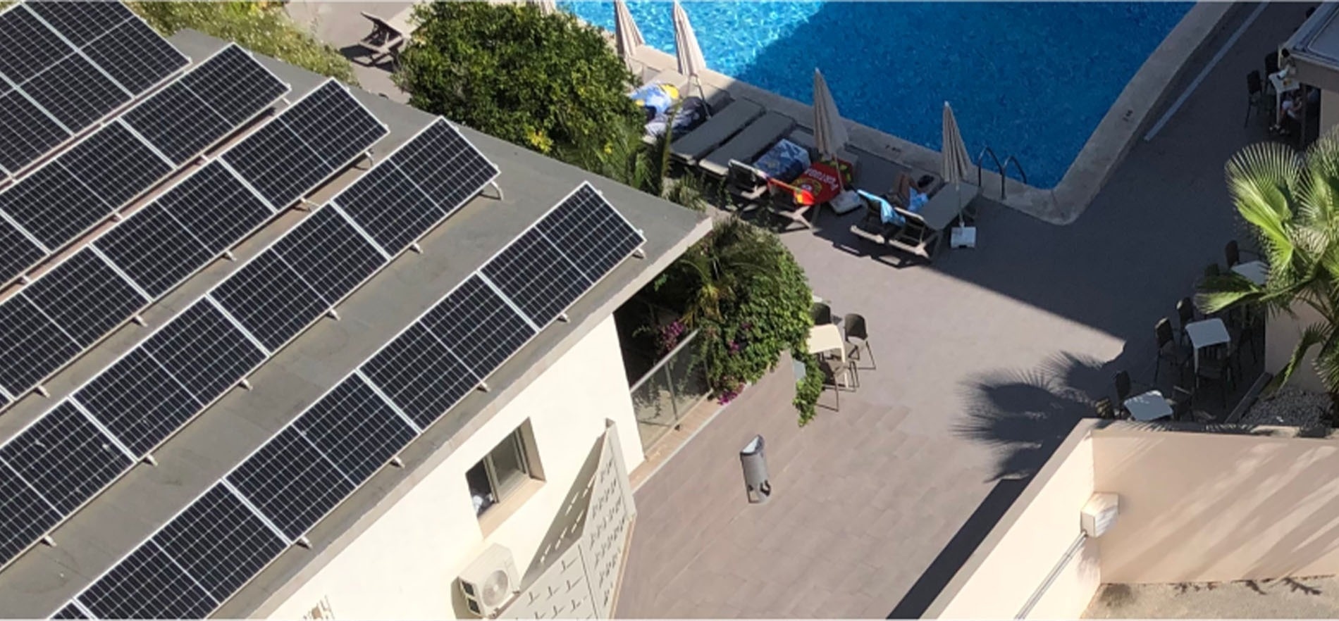 solar panels on the roof of a building next to a pool