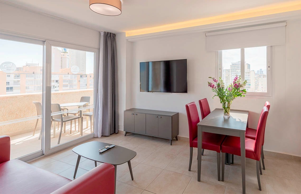 a living room with a table and chairs and a flat screen tv