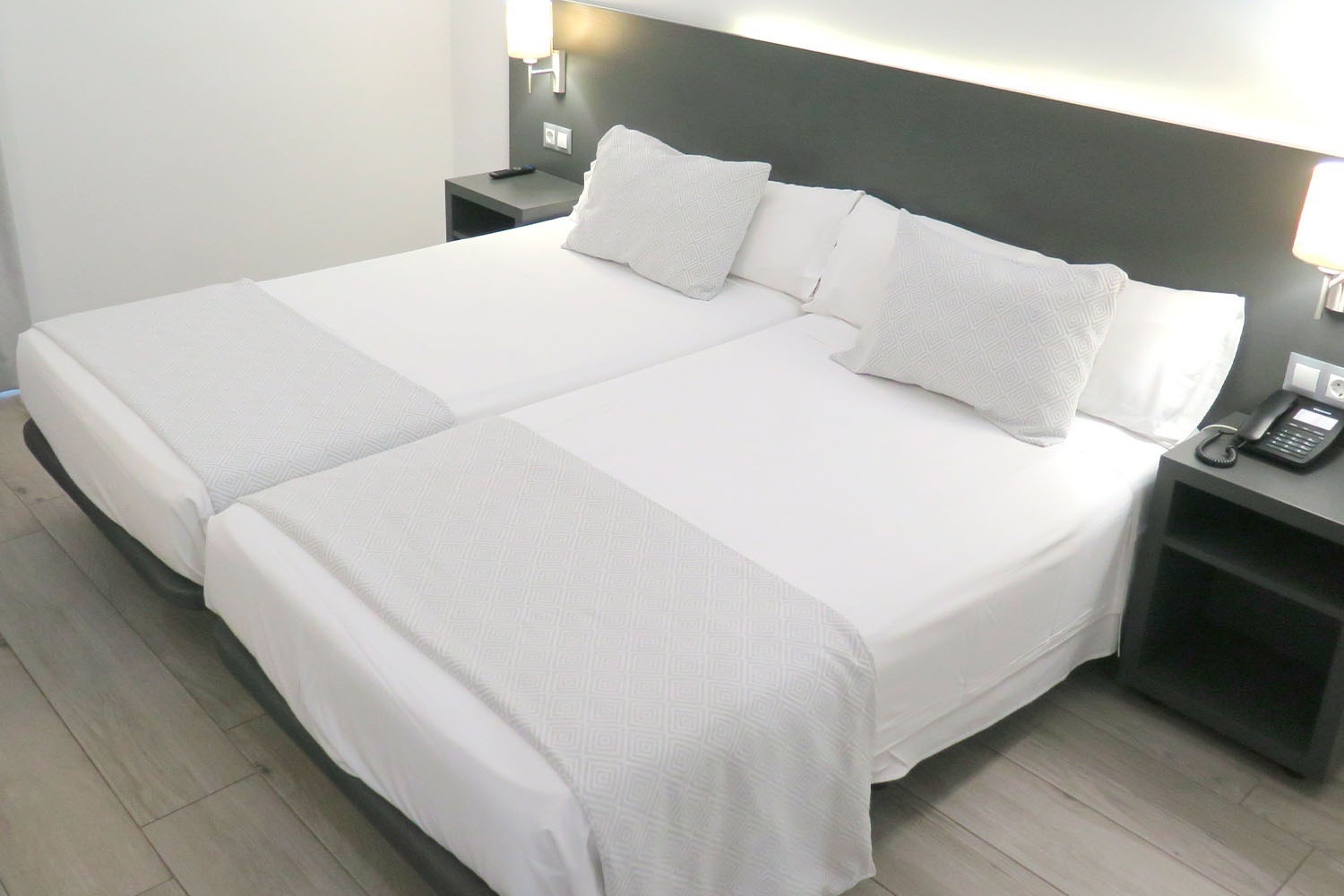 a hotel room with two beds and a phone on the nightstand