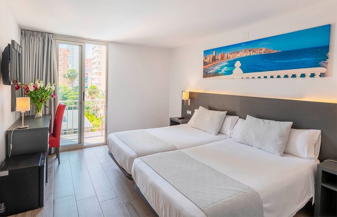 a hotel room with two beds and a painting on the wall