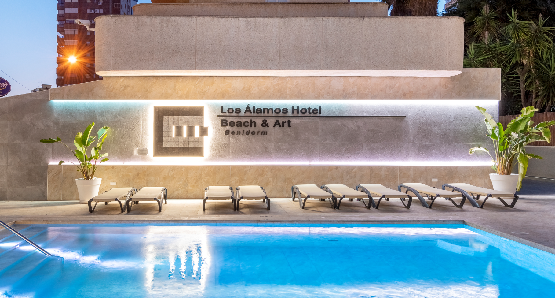 la piscina del hotel los alamos está iluminada por la noche