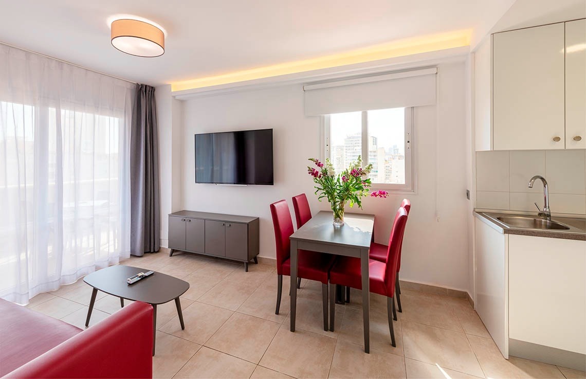 a living room with a table and chairs and a flat screen tv