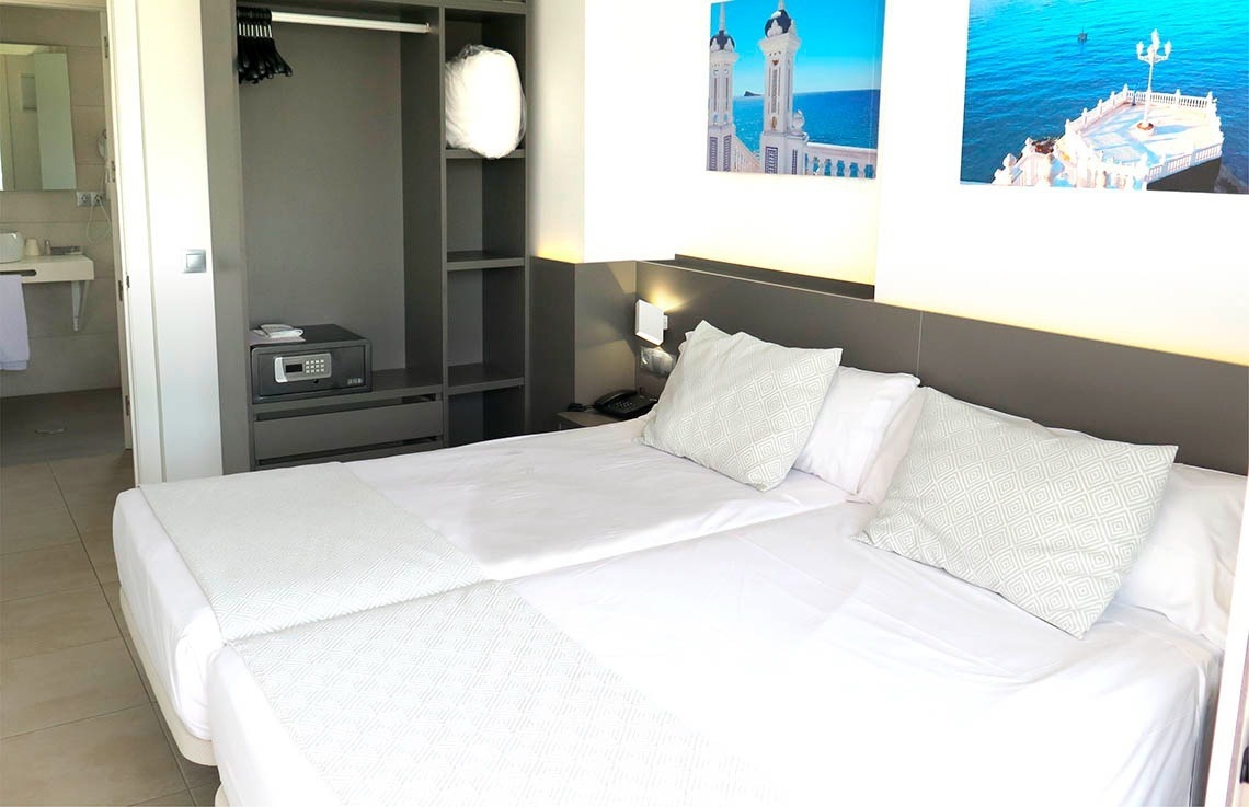 a hotel room with two beds and a safe