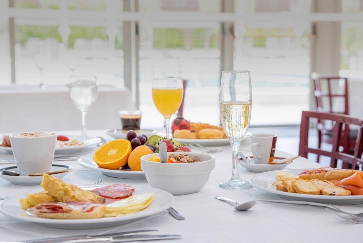 una mesa llena de platos de comida y copas de champán