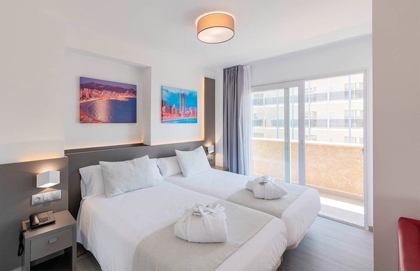 una habitación de hotel con dos camas y una pintura en la pared