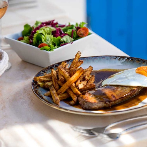 Delicious meal at Aldeia da Pedralva: steak, fries, salad, and rosé.
