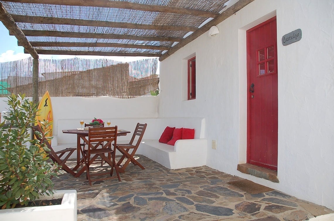 a white building with a red door and a sign that says cottage