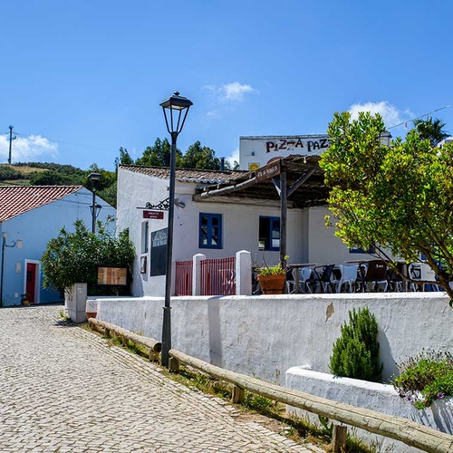 Charming Aldeia da Pedralva restaurant with outdoor seating and cobblestone street.