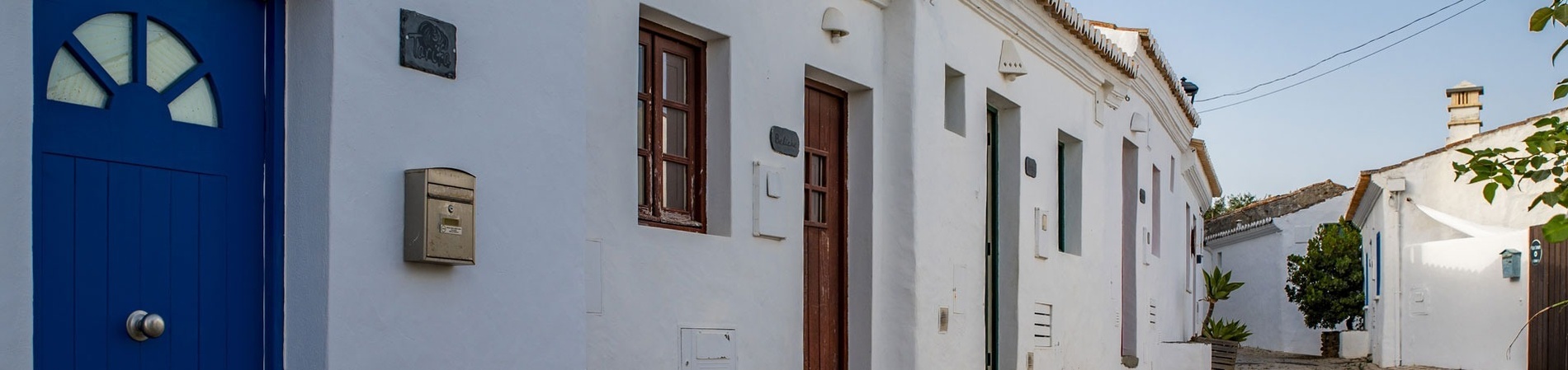 uma casa branca com uma porta azul e uma caixa de correio
